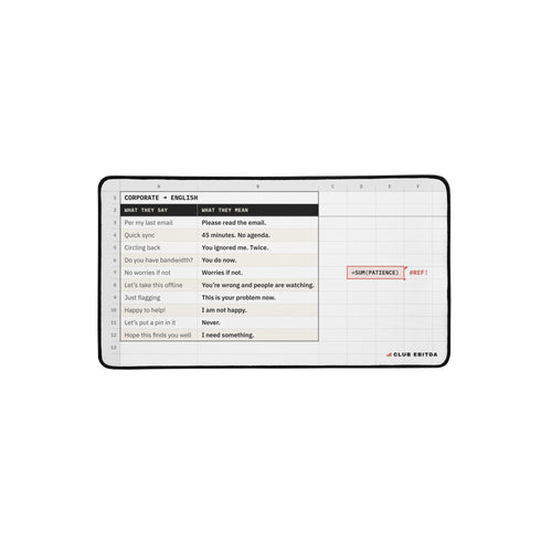 Corporate Translation desk mat, 12 x 22 in: white spreadsheet-style print titled CORPORATE → ENGLISH with WHAT THEY SAY and WHAT THEY MEAN columns, a red =SUM(PATIENCE) #REF! cell and a black edge